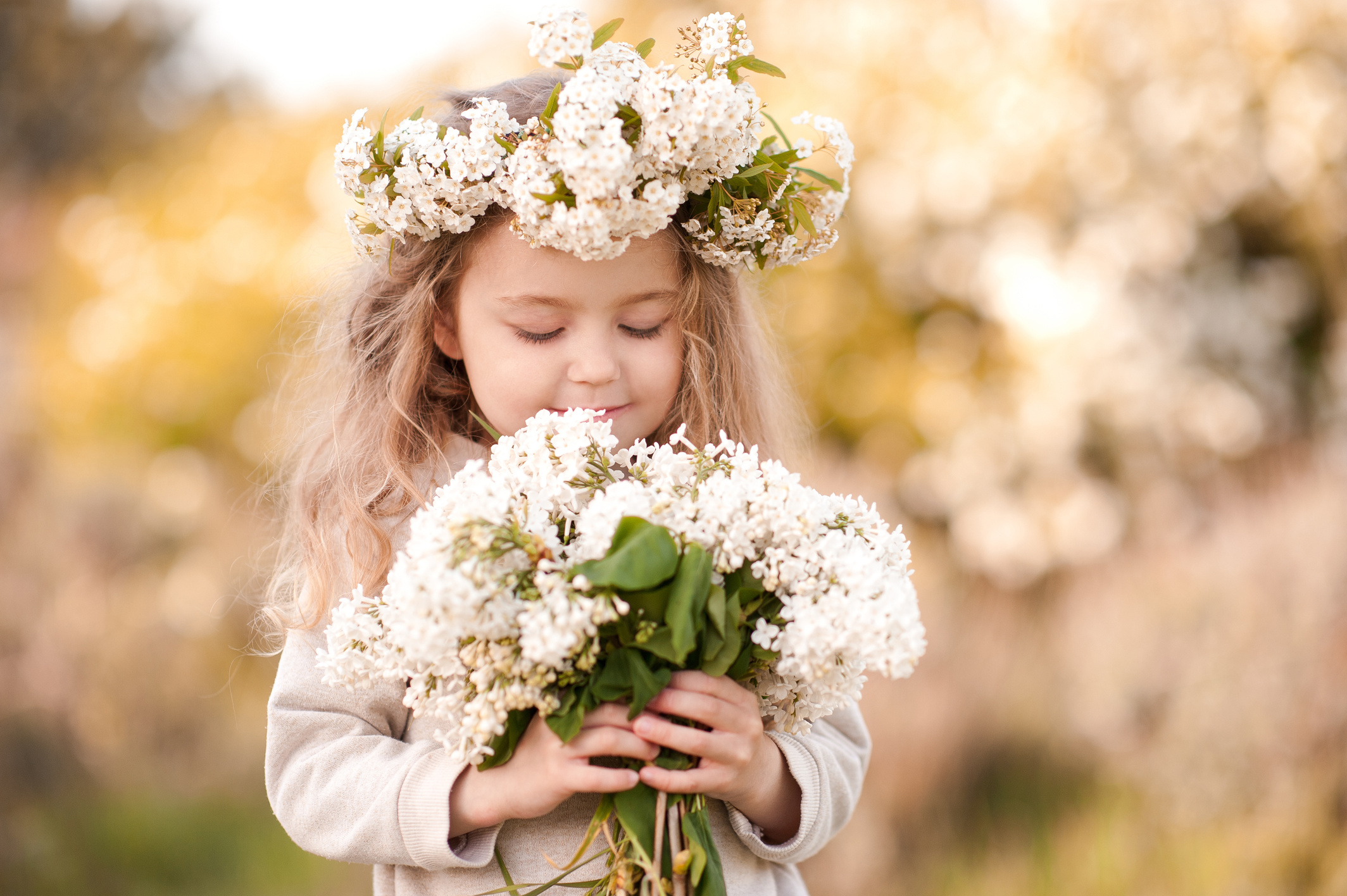 Child girl smelling flowers outdoors